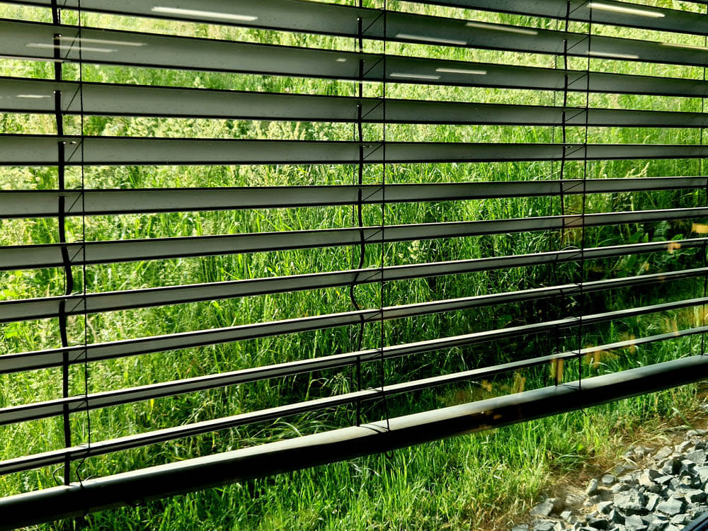 Dining table by the window. retractable automatic blinds. the sensor evaluates the lighting of the building and issues a command to the shutter motors. large windows of office building. blacked out